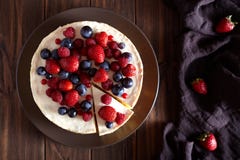 Pastel de queso cremoso hecho en casa delicioso de Nueva York del mascarpone con las bayas en la tabla de madera oscura Viev supe imagenes de archivo Pastel de queso cremoso hecho en casa delicioso de Nueva York del mascarpone con las bayas en la tabla de madera oscura Viev supe imagenes de archivo