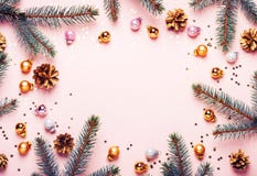 Pastel Pink Christmas Background. Festive frame of fir branches, golden balls and confetti stock photos Pastel Pink Christmas Background. Festive frame of fir branches, golden balls and confetti stock photos