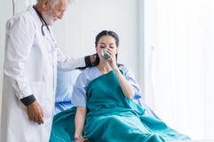Patient asian woman taking a medicine and man doctor helped to her at the hospital stock photo Patient asian woman taking a medicine and man doctor helped to her at the hospital stock photo