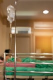 Patient dormant dans le lit recevant l'égouttement de la solution saline, blurre photo stock Patient dormant dans le lit recevant l'égouttement de la solution saline, blurre photo stock