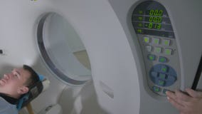 Patient in einem Scanner des Notkrankenhauses MRI Mann legt in das magnetische Resonanz- Bildgerät und macht tomographisches Scan stock video footage Patient in einem Scanner des Notkrankenhauses MRI Mann legt in das magnetische Resonanz- Bildgerät und macht tomographisches Scan stock video footage
