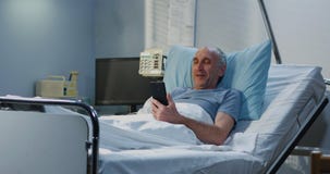 Patient masculin employant l'appel visuel dans la chambre d'h?pital image stock Patient masculin employant l'appel visuel dans la chambre d'h?pital image stock