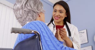 Patient plus âgé remerciant le docteur mexicain de femme photographie stock libre de droits Patient plus âgé remerciant le docteur mexicain de femme photographie stock libre de droits
