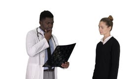 Patienten kommer att manipulera med fysioterapeuten f?r x-str?len som f?rklarar r?ntgenstr?len till patienten p? vit bakgrund royaltyfria bilder Patienten kommer att manipulera med fysioterapeuten f?r x-str?len som f?rklarar r?ntgenstr?len till patienten p? vit bakgrund royaltyfria bilder
