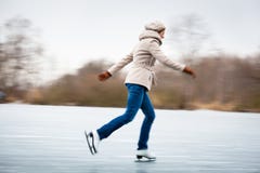 Patinagem no gelo da jovem mulher fora em uma lagoa imagens de stock royalty free Patinagem no gelo da jovem mulher fora em uma lagoa imagens de stock royalty free