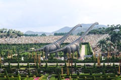 PATTAYA, TAILANDIA - 24 APRILE 2019: Valle gigante del dinosauro di visita turistica al giardino di Nong Nooch fotografia stock PATTAYA, TAILANDIA - 24 APRILE 2019: Valle gigante del dinosauro di visita turistica al giardino di Nong Nooch fotografia stock