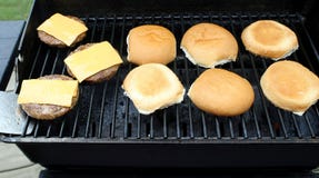 Patties χάμπουργκερ με τις επεξεργασμένες φέτες τυριών που μαγειρεύουν σε μια υπαίθρια σχάρα επιτραπέζιων κορυφών στοκ φωτογραφίες Patties χάμπουργκερ με τις επεξεργασμένες φέτες τυριών που μαγειρεύουν σε μια υπαίθρια σχάρα επιτραπέζιων κορυφών στοκ φωτογραφίες