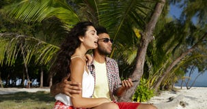 Paumes de Sit Embracing On Beach Under de couples utilisant le téléphone intelligent de cellules, l'homme de sourire heureux et p banque de vidéos Paumes de Sit Embracing On Beach Under de couples utilisant le téléphone intelligent de cellules, l'homme de sourire heureux et p banque de vidéos