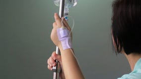 Paziente della donna in ospedale con il dispositivo di venipunzione salino Paziente della donna in ospedale con il dispositivo di venipunzione salino