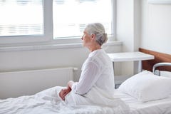 Paziente senior della donna che si trova a letto al reparto di ospedale fotografia stock Paziente senior della donna che si trova a letto al reparto di ospedale fotografia stock