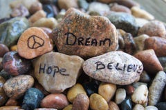 Peace, Hope, Dream and Believe Handwritten on River Rock stock images Peace, Hope, Dream and Believe Handwritten on River Rock stock images