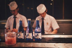 Pechino, Cina - 11 giugno 2018: Il cuoco unico cinese due sta cucinando i sushi davanti agli ospiti del ristorante immagine stock libera da diritti Pechino, Cina - 11 giugno 2018: Il cuoco unico cinese due sta cucinando i sushi davanti agli ospiti del ristorante immagine stock libera da diritti