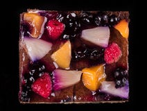 Pedazo de torta de la fruta con la jalea y la crema Fondo negro Visión superior foto de archivo Pedazo de torta de la fruta con la jalea y la crema Fondo negro Visión superior foto de archivo