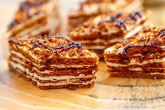 Pedaços de bolo com camadas de creme na lona em uma tabela de madeira imagem de stock Pedaços de bolo com camadas de creme na lona em uma tabela de madeira imagem de stock