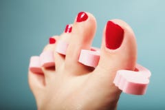 Pedicura del pie que aplica las uñas del pie rojas en azul Foto de archivo Pedicura del pie que aplica las uñas del pie rojas en azul Foto de archivo