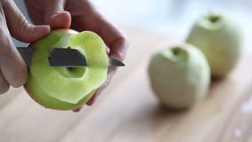 Peeling of apple. Video Peeling of apple on the wood background Peeling of apple. Video Peeling of apple on the wood background