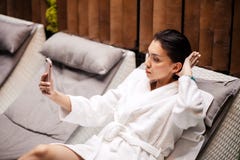 Peignoir blanc de port de jeune femme beauitiful se trouvant sur le loung image stock Peignoir blanc de port de jeune femme beauitiful se trouvant sur le loung image stock