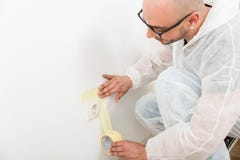 Peintre collant la bande près de la prise photographie stock libre de droits Peintre collant la bande près de la prise photographie stock libre de droits