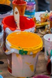 Peintures multicolores dans des pots et la brosse sur la table, chaos créatif Photographie stock libre de droits Peintures multicolores dans des pots et la brosse sur la table, chaos créatif Photographie stock libre de droits