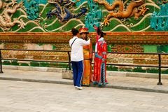 Pekín, China, 06/06/2018 de dos muchachas chinas en trajes nacionales se fotografía cerca de la pared de nueve dragones en prohib foto de archivo libre de regalías Pekín, China, 06/06/2018 de dos muchachas chinas en trajes nacionales se fotografía cerca de la pared de nueve dragones en prohib foto de archivo libre de regalías
