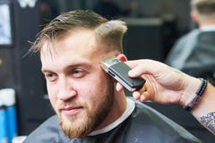 Peluquero o estilista en el trabajo Pelo del corte del peluquero del cliente imágenes de archivo libres de regalías Peluquero o estilista en el trabajo Pelo del corte del peluquero del cliente imágenes de archivo libres de regalías