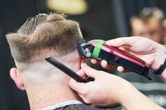 Peluquero que hace el corte de pelo masculino Pelo del corte del peluquero del cliente imagen de archivo libre de regalías Peluquero que hace el corte de pelo masculino Pelo del corte del peluquero del cliente imagen de archivo libre de regalías