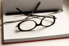 Pen note book and glasses on white stock photography Pen note book and glasses on white stock photography