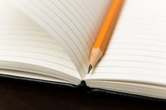 Pencil on the pages of an open notebook for records Stock Photo Pencil on the pages of an open notebook for records Stock Photo
