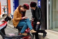 Pengzhou, China: Adolescentes que verificam seus telefones celulares foto de stock royalty free Pengzhou, China: Adolescentes que verificam seus telefones celulares foto de stock royalty free
