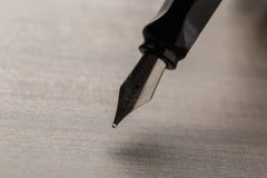 Penna stilografica nera sulla tavola immagine stock Penna stilografica nera sulla tavola immagine stock