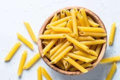 Penne макаронных изделий в деревянном шаре на белой таблице Стоковое Фото Penne макаронных изделий в деревянном шаре на белой таблице Стоковое Фото