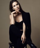 Pensiero di seduta della giovane bella ragazza dei pantaloni a vita bassa sexy in rivestimento e biancheria intima marroni della immagini stock libere da diritti Pensiero di seduta della giovane bella ragazza dei pantaloni a vita bassa sexy in rivestimento e biancheria intima marroni della immagini stock libere da diritti