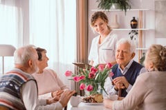 pensionati a casa di riposo che parlano durante lo spuntino di pomeriggio immagine stock libera da diritti pensionati a casa di riposo che parlano durante lo spuntino di pomeriggio immagine stock libera da diritti