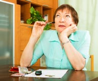 Pensionato femminile che fa lavoro finanziario dell'interno Immagine Stock Pensionato femminile che fa lavoro finanziario dell'interno Immagine Stock