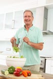 pensionär för sallad för kökman modern förberedande arkivbild pensionär för sallad för kökman modern förberedande arkivbild