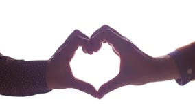 Close up of male gay couple making hand heart