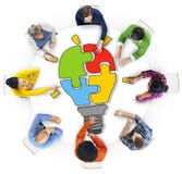 People with Light Bulb Jigsaw Puzzle Forming royalty free stock photography People with Light Bulb Jigsaw Puzzle Forming royalty free stock photography