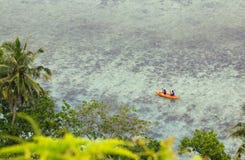 People in sea kayak on island coast tropical sea