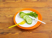 Pepino cortado em placas, na forquilha e na faca plásticas descartáveis Imagem de Stock Pepino cortado em placas, na forquilha e na faca plásticas descartáveis Imagem de Stock