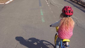 Peque?a bici rubia de cinco a?os del montar a caballo de la muchacha en un parque viejo almacen de video Peque?a bici rubia de cinco a?os del montar a caballo de la muchacha en un parque viejo almacen de video
