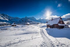 Pequeña cabaña de la montaña en valle del invierno en la puesta del sol Imagen de archivo Pequeña cabaña de la montaña en valle del invierno en la puesta del sol Imagen de archivo