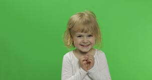 Pequeña muchacha rubia feliz en la camiseta blanca Ni?o rubio lindo Fabricaci?n de caras foto de archivo libre de regalías Pequeña muchacha rubia feliz en la camiseta blanca Ni?o rubio lindo Fabricaci?n de caras foto de archivo libre de regalías