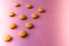 Pequeñas píldoras redondas pharmaceptic médicas hermosas amarillo-naranja, vitaminas, drogas, antibióticos en un fondo púrpura ro imágenes de archivo libres de regalías Pequeñas píldoras redondas pharmaceptic médicas hermosas amarillo-naranja, vitaminas, drogas, antibióticos en un fondo púrpura ro imágenes de archivo libres de regalías