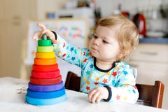 Pequeño bebé hermoso lindo adorable que juega con la pirámide de madera educativa del juguete del arco iris fotografía de archivo libre de regalías Pequeño bebé hermoso lindo adorable que juega con la pirámide de madera educativa del juguete del arco iris fotografía de archivo libre de regalías