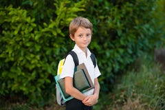 Pequeño colegial del retrato con la mochila y los libros outdoors imagenes de archivo Pequeño colegial del retrato con la mochila y los libros outdoors imagenes de archivo
