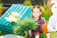 Pequeño kazakh adorable, muchacha asiática del niño con la zanahoria en fondo de la naturaleza del verde del verano imagen de archivo Pequeño kazakh adorable, muchacha asiática del niño con la zanahoria en fondo de la naturaleza del verde del verano imagen de archivo