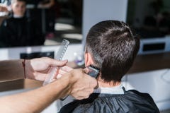 Perfect trim. Rear view close-up of young man getting haircut by hairdresser with electric razor. stock image Perfect trim. Rear view close-up of young man getting haircut by hairdresser with electric razor. stock image