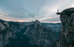 Perhaps the best view of glacier point where this unknown adventurer dares to stand on the edge stock photography Perhaps the best view of glacier point where this unknown adventurer dares to stand on the edge stock photography