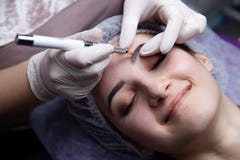 Permanent Makeup For Eyebrows. Microblading brow. Beautician Doing Eyebrow Tattooing For Female Face. Beautiful young royalty free stock image Permanent Makeup For Eyebrows. Microblading brow. Beautician Doing Eyebrow Tattooing For Female Face. Beautiful young royalty free stock image