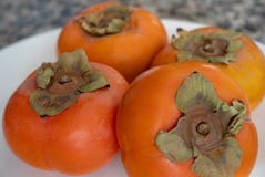 Persimmons on white plate. stock photography Persimmons on white plate. stock photography